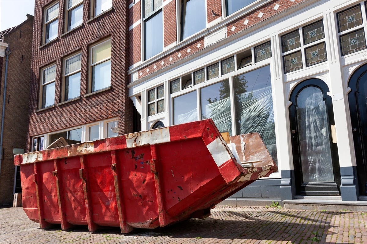 Roll-off container on a street filled with renovation waste