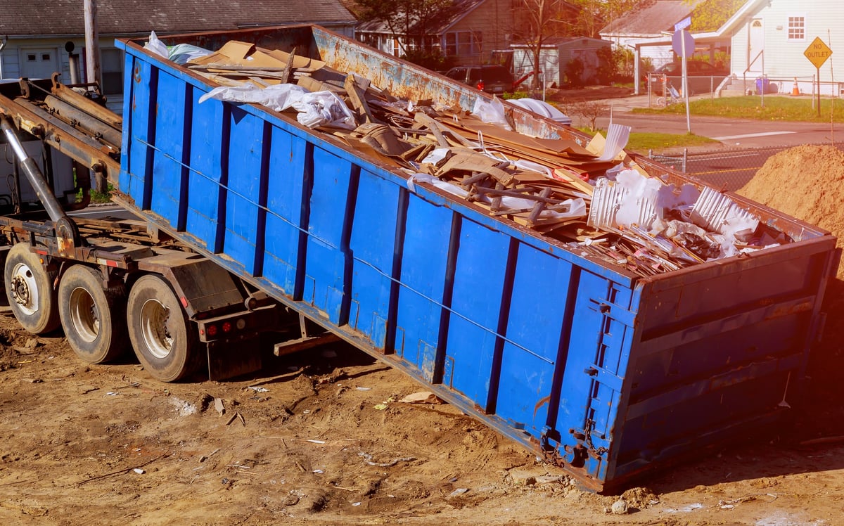 Debris container being loaded with unwanted items during a removal